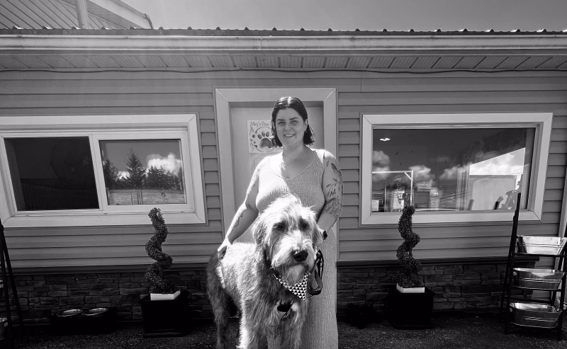 Meg posing with a canine client in front of her Elora location at 7455 Speers Rd, Elora, ON N0B 1S0